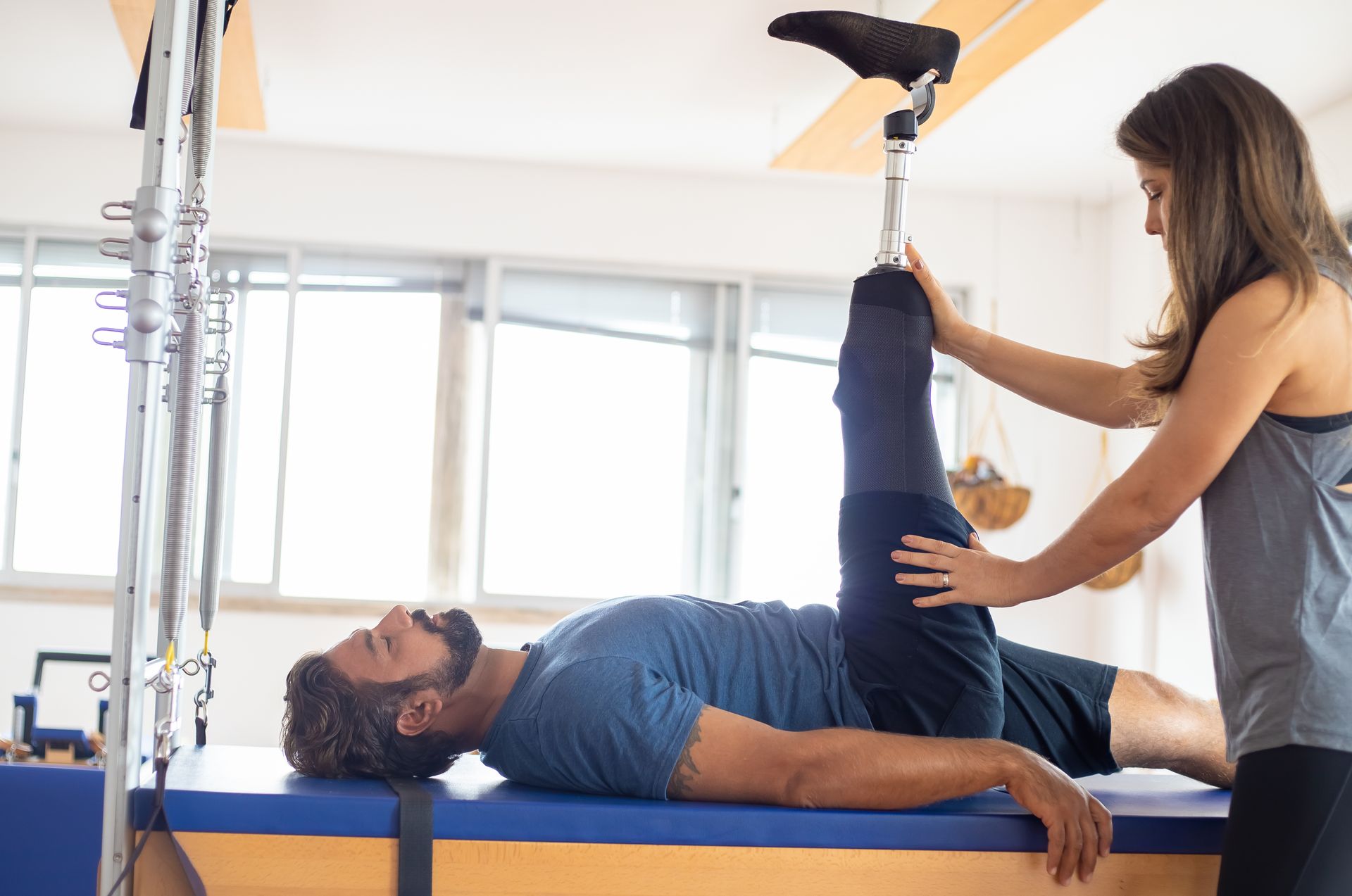 Fisioterapeuta guiando a un paciente en un ejercicio de rehabilitación